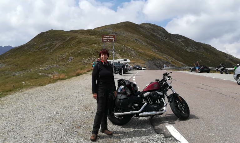 questa è la foto della dottoressa Paola Mandich in tenuta sportiva accanto alla sua Harley Davidson rossa